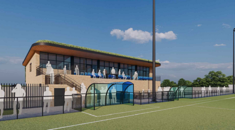 A computer generated image of a new football pavilion, build next to a green football pitch. A number of silhouette figures are placed around the pitch and stood on a balcony on the pavilion.