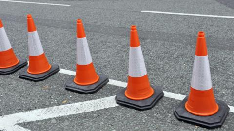 Orange and white traffic cones on a road