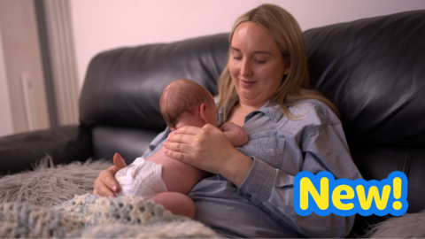 Mum looks at baby on her chest