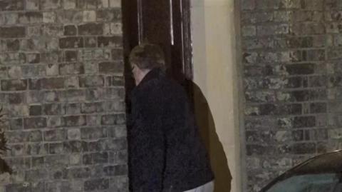 The back of Peter Mandelson as he enters the front door of his house.