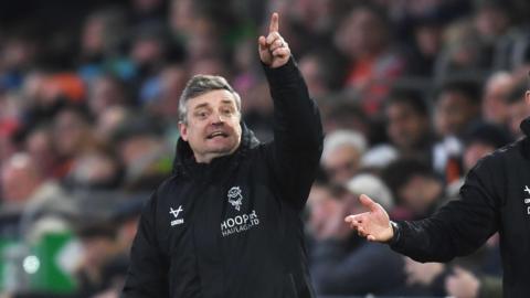 Lincoln City boss Michael Skubala points and shouts instructions to his players