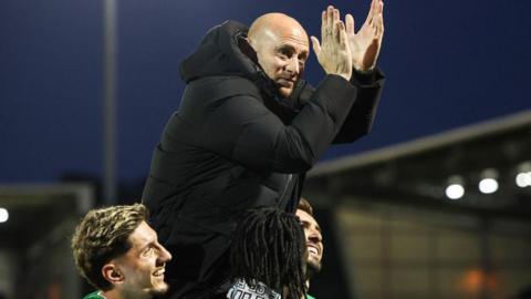 David Gray is carried aloft by his players after Hibs clinched third place in the Scottish Premiership with a game to spare.