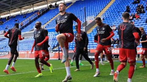 Crawley players warm-up at Reading's Select Car Leasing Stadium