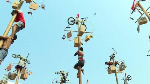 Indonesians take part in a greasy pole climbing contest - a tradition that dates back to Dutch colonial days.