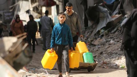 Palestinians carry and fill up the water bottles to meet their water needs from the few underground water sources and mobile tanks as they have limited access to water due to Israeli attacks in Zeitoun neighborhood in Gaza City, Gaza on March 3, 2024