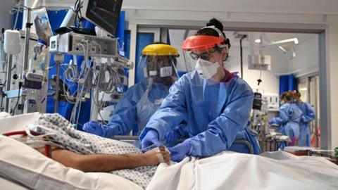 Clinical staff wear Personal Protective Equipment (PPE) as they care for a patient at the Intensive Care unit at Royal Papworth Hospital on May 5, 2020 in Cambridge, England