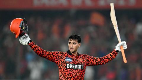 Abhishek Sharma raises his bat and helmet to acknowledge the crowd in Hyderabad