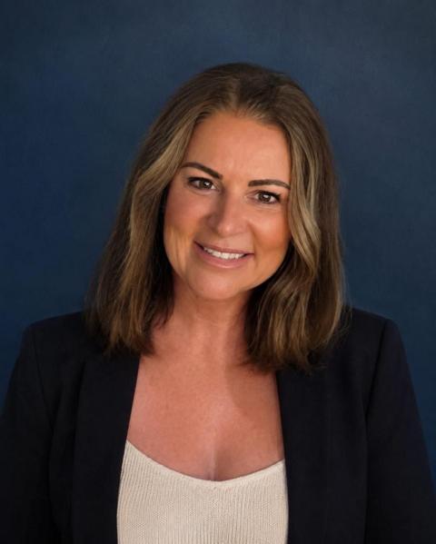 Restore Britain candidate, Rebecca Shepherd. She has shoulder-length dark hair, is wearing a dark blazer and a white blouse. 