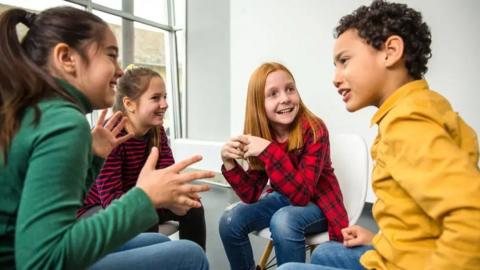 Four children sitting talking