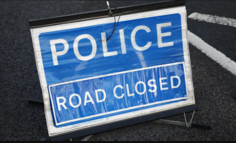 Blue police sign saying 'road closed'