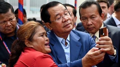 Cambodian Prime Minister leader Hun Sen takes a selfie with a supporter in Phnom Penh