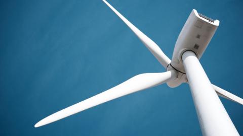 A wind turbine against a blue sky