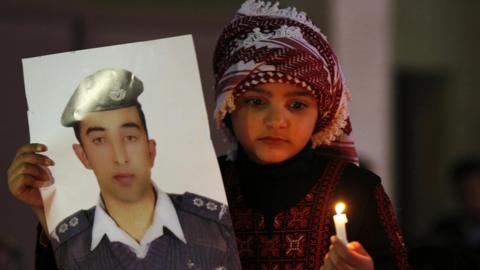 A Jordanian girl holds a poster of pilot Muath al-Kasaesbeh