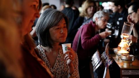 a woman samples coffee at a Starbucks investor's event