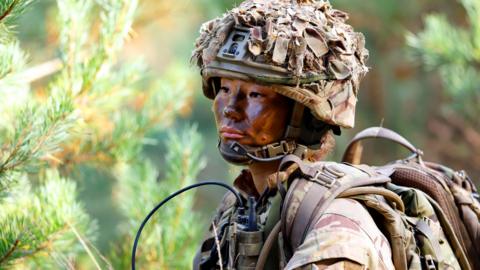 A female soldier of 1st Battalion London Guards takes part in a training exercise on Hankley Common 