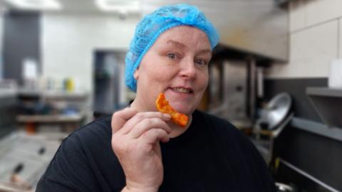 woman holding up an orange chip