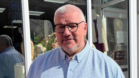 Steve Payne in black rimmed glasses and a blue checked shirt