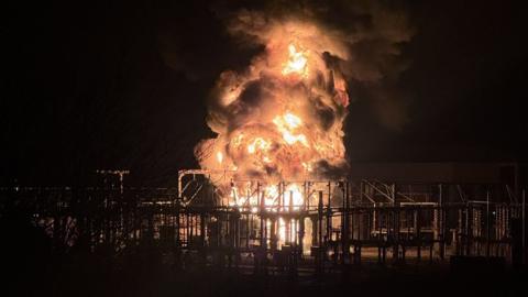 A blazing inferno towers over transformer within the electrical substation in Hayes