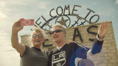 Harper Steele, wearing black glasses with her hair swept up, takes a selfie with Will Ferrell, who has short grey hair and is wearing black sunglasses