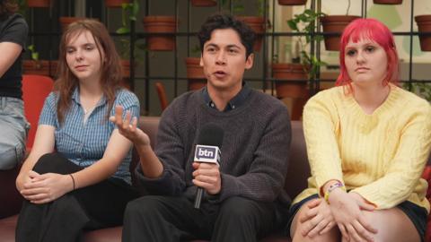 Three people sitting on a sofa.