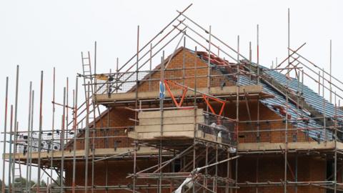 A half-built house surrounded by scaffolding