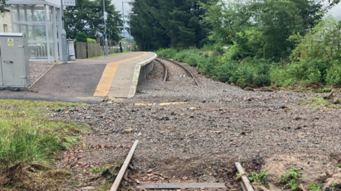 Tracks at Achanalt railway station covered in silt and debris left after flooding.