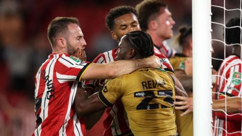 Sheffield United's Rhys Norrington-Davies and Wrexham's Sebastian Revan tussle with each other