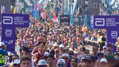 Thousands of runners pass across Tower Bridge during the London Marathon 2025