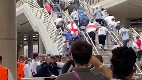 Football fans run up stairs