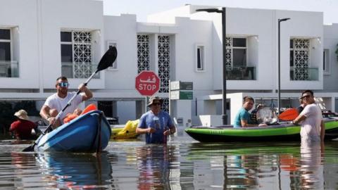 Residents move they belongings on kayaks up in a gangbangin' flooded residential area up in Dubai
