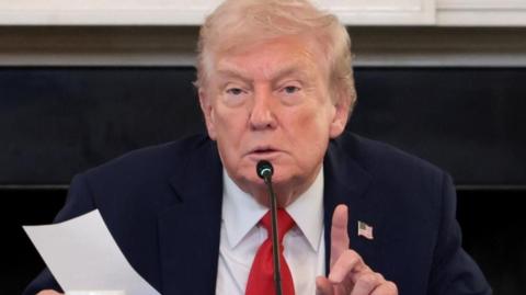 Donald Trump holds the note handed to him by Rubio