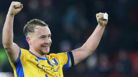 Louis Reed with both fists in the air after scoring for Mansfield Town against Sheffield United