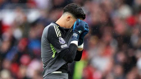 Altay Bayindir reacts with his shirt over his face