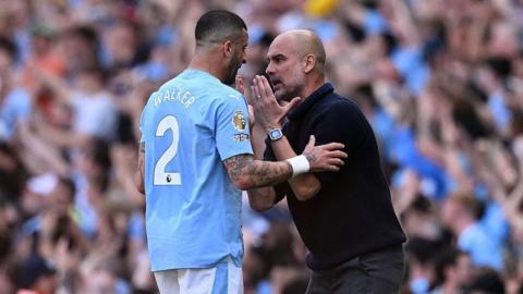 Kyle Walker and Pep Guardiola have a discussion on the touchline.