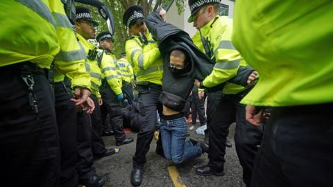 Police remove a protester after demonstrators formed a blockade