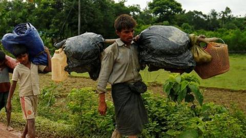 Rohingyas walk along the road to reach to the refugee camp after crossing the border in Cox"s Bazar