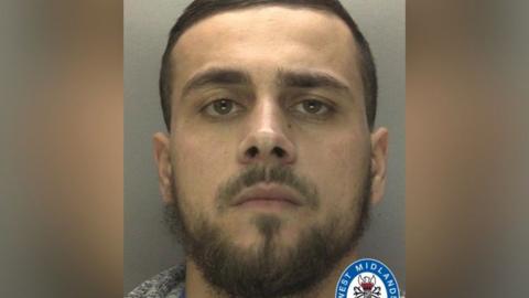 Kye Lemathy seen in a police mugshot. He has a beard and short hair and is staring at the camera.