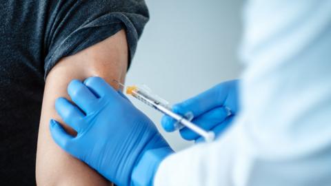 Close-up of a volunteer being injected with trial vaccine