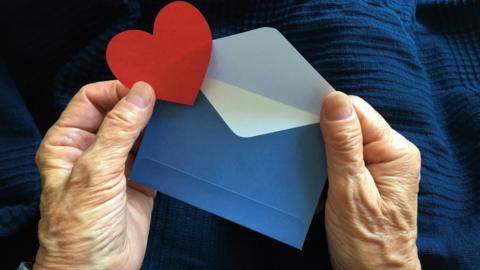 Elderly person holding a Valentine's card