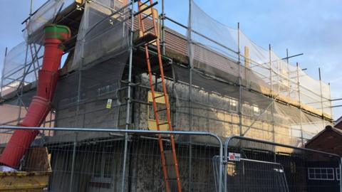 The house covered in scaffolding