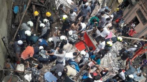 Rescue workers and residents search for survivors at the site of a collapsed building in Mumbai, India, July 16, 2019