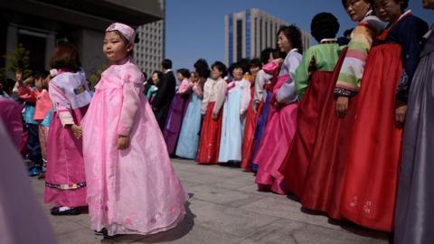 People wearing traditional Korean 'hanbok' dresses take part in a parade in the central Gwanghwamun square in Seoul