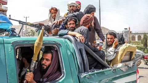 Taliban fighters are seen on the back of a vehicle in Kabul, Afghanistan, on 16 August