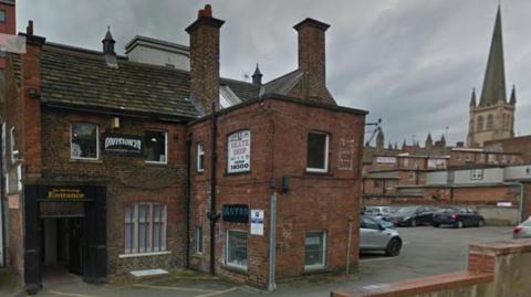 A red brick property with a car park and the cathedral in the background