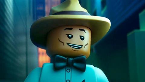 Pharrell Williams as a Lego figure in Piece By Piece. He is wearing his signature hat with a blue a shirt and black bow tie.