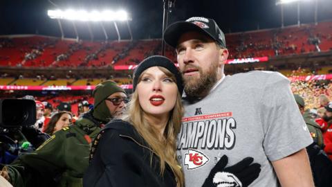 Taylor Swift and Travis Kelce in a sports stadium
