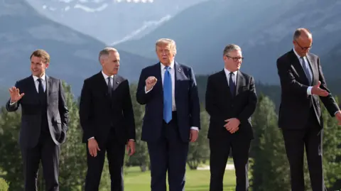 French President Emmanuel Macron, Canada Prime Minister Mark Carney, U.S. President Donald Trump, British Prime Minister Keir Starmer, and German Chancellor Friedrich Merz prepare for a family photo during the G7 Summit, in Kananaskis, Alberta, Canada