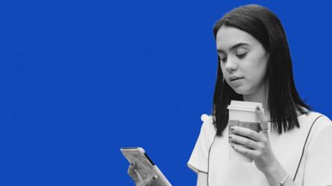 Black-and-white cutout of a young woman looking at her smartphone and holding a takeaway coffee cup against a bold blue background