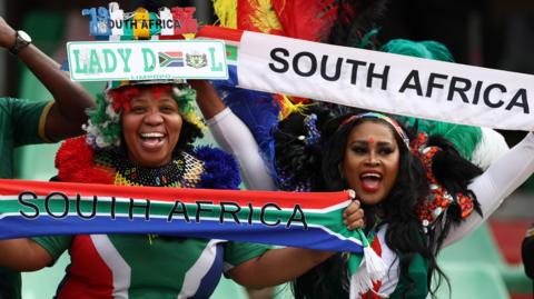 South Africa fans hold up banners and scarves in the national colours