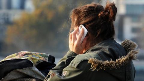 A generic stock photo of a woman using a mobile phone